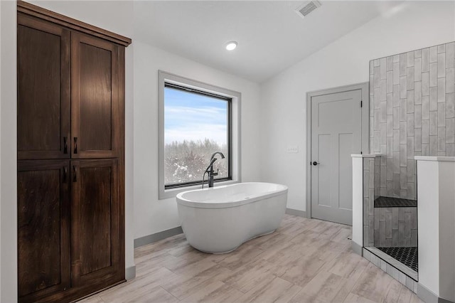 bathroom with vaulted ceiling and a bathing tub