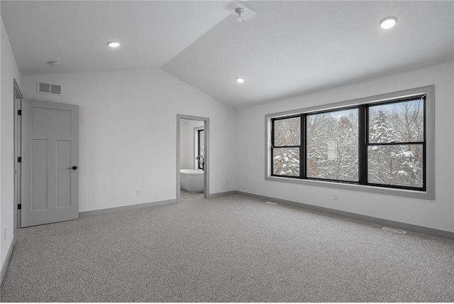 unfurnished bedroom featuring ensuite bathroom, carpet, and lofted ceiling