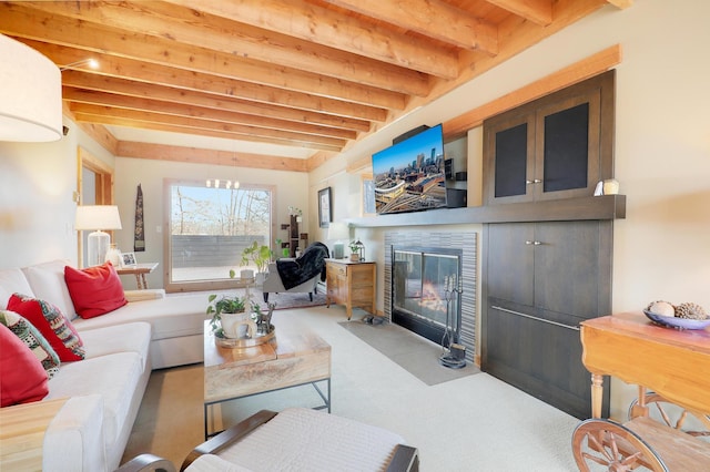 living area with beamed ceiling, carpet flooring, and a fireplace with flush hearth