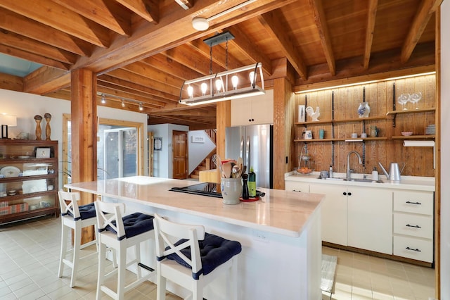 kitchen featuring white cabinetry, wooden ceiling, freestanding refrigerator, and a sink