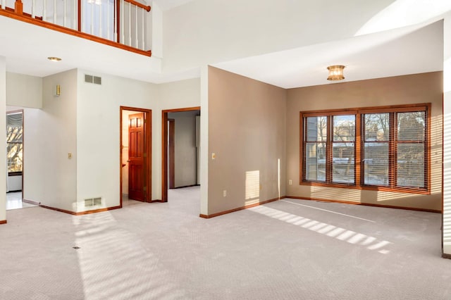 interior space with a towering ceiling and light carpet