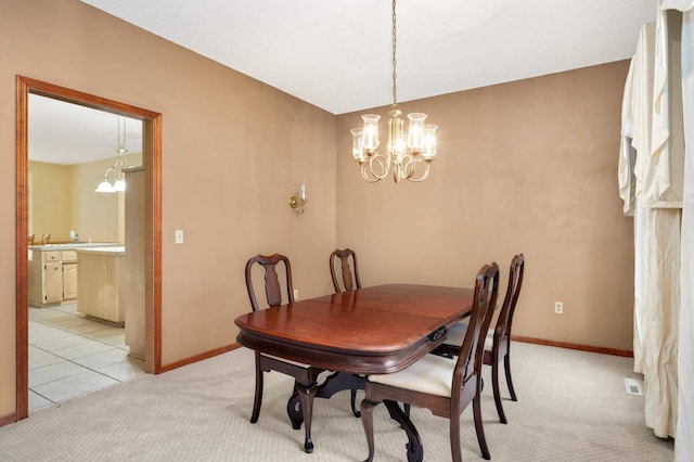 dining room featuring light carpet and a notable chandelier