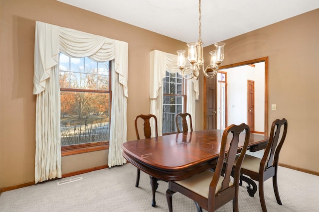 carpeted dining room featuring a notable chandelier