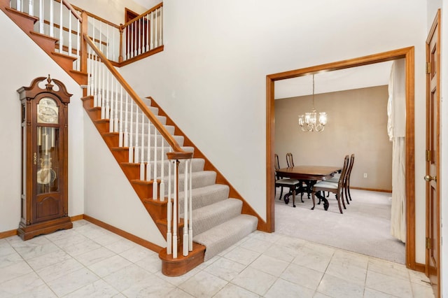 stairway with carpet flooring and a notable chandelier