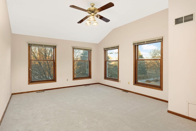 carpeted spare room featuring vaulted ceiling and ceiling fan