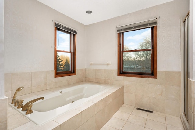 bathroom featuring tile patterned floors and tiled tub