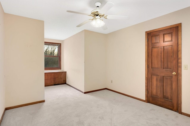 spare room with ceiling fan and light colored carpet