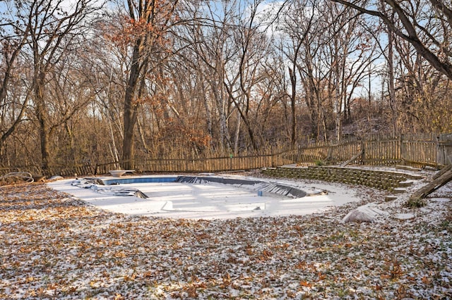 snow covered pool with a diving board and a patio