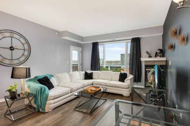 living room with a tile fireplace and hardwood / wood-style floors