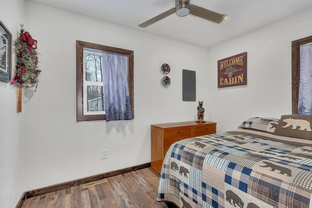 bedroom featuring light wood-type flooring, electric panel, and ceiling fan