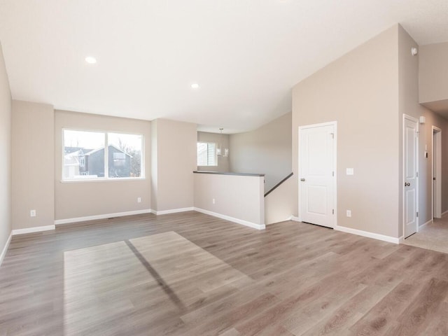 unfurnished living room featuring light hardwood / wood-style floors and high vaulted ceiling