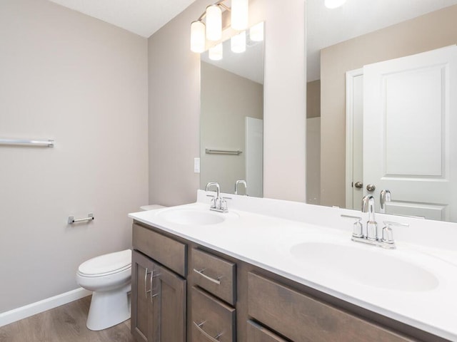 bathroom with vanity, toilet, and wood-type flooring