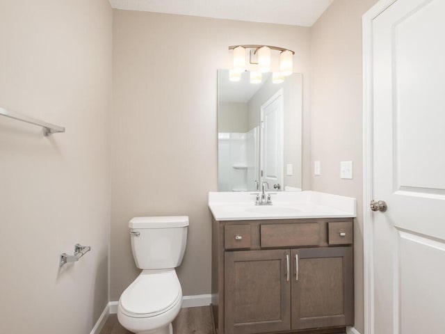 bathroom with hardwood / wood-style flooring, vanity, and toilet