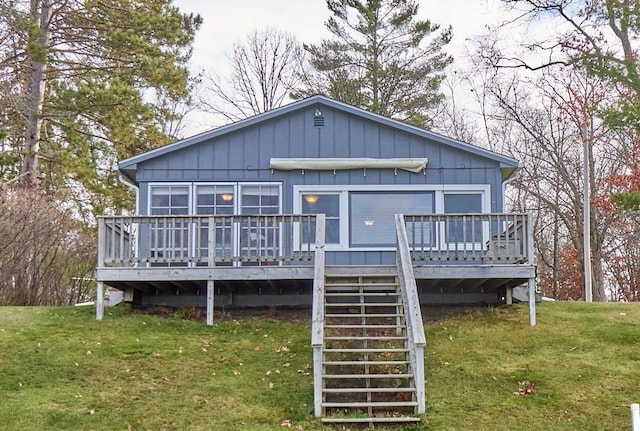 back of property featuring a lawn and a wooden deck