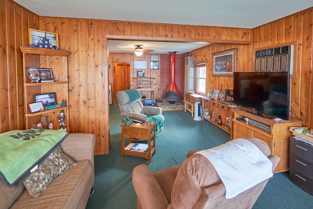 carpeted living room with a wood stove and wood walls