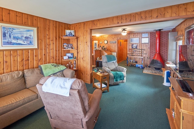 carpeted living room with a wood stove and wooden walls