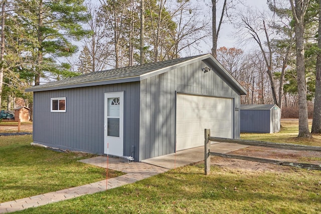 view of outbuilding featuring a garage and a lawn