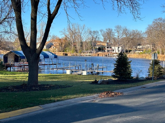 dock area with a water view and a lawn