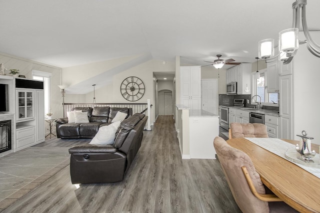 living room featuring vaulted ceiling, sink, ceiling fan, and light hardwood / wood-style floors