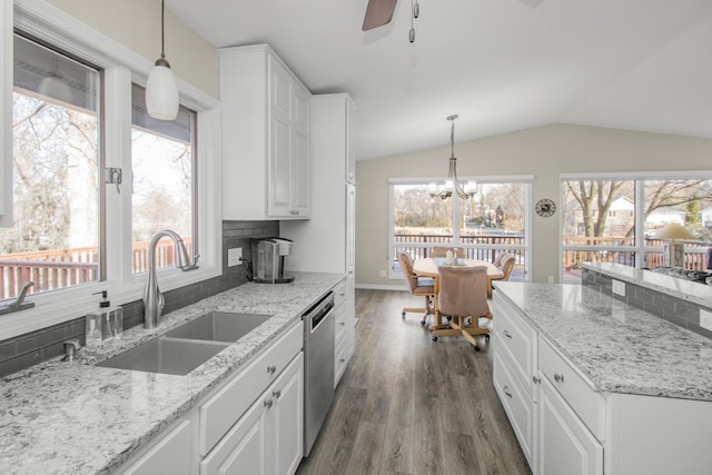 kitchen with backsplash, decorative light fixtures, vaulted ceiling, and sink