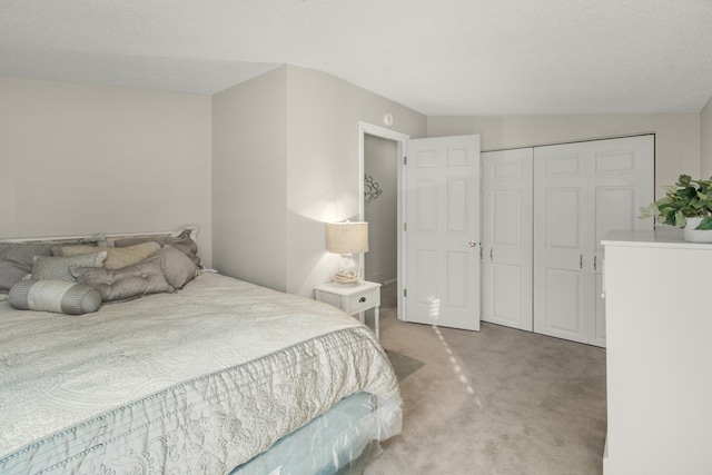 carpeted bedroom featuring lofted ceiling, a closet, and a textured ceiling