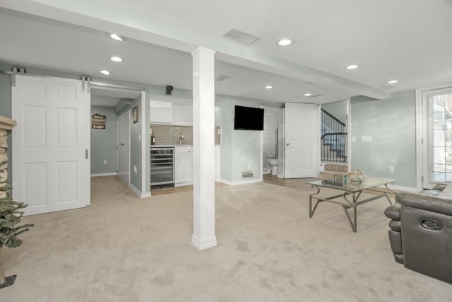 carpeted living room with wine cooler and a barn door