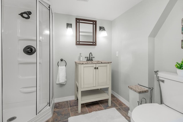 bathroom with walk in shower, vanity, and toilet