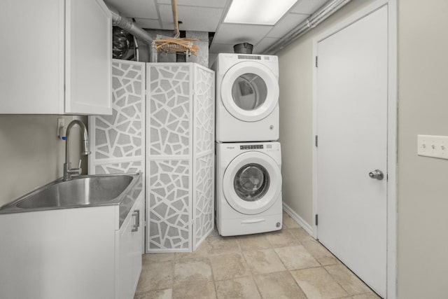 washroom featuring cabinets, stacked washer / drying machine, and sink