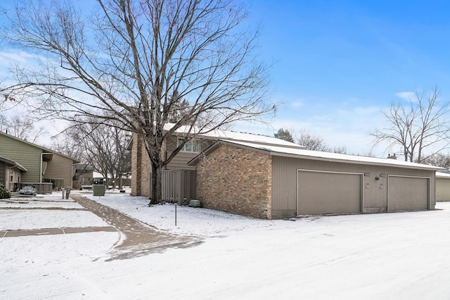 view of snow covered exterior with a garage