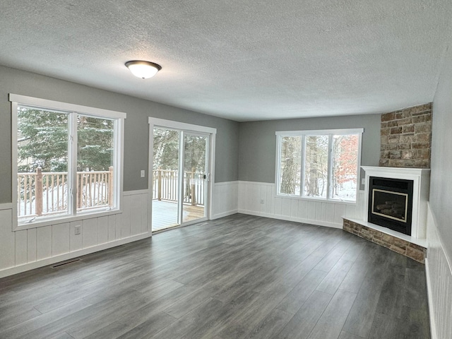 unfurnished living room with a textured ceiling and dark hardwood / wood-style floors