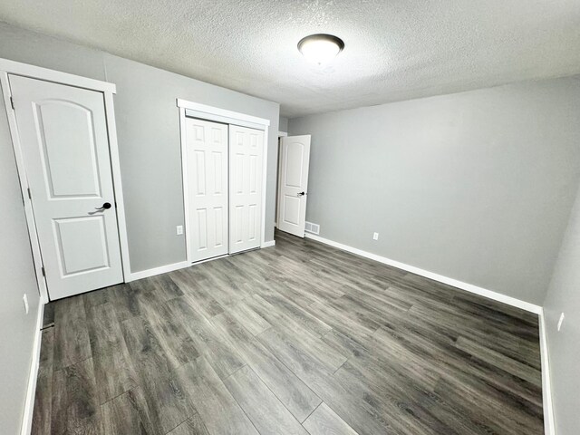 40308 County Road 3, Fifty Lakes, MN 56448 - unfurnished bedroom featuring dark wood finished floors, a closet, and a textured ceiling