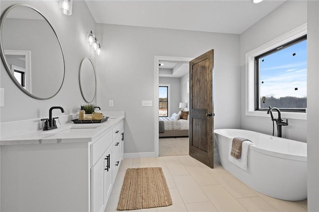 bathroom with tile patterned floors, a bathtub, and vanity