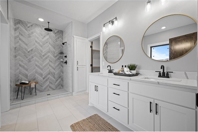 bathroom featuring tile patterned flooring, vanity, and tiled shower