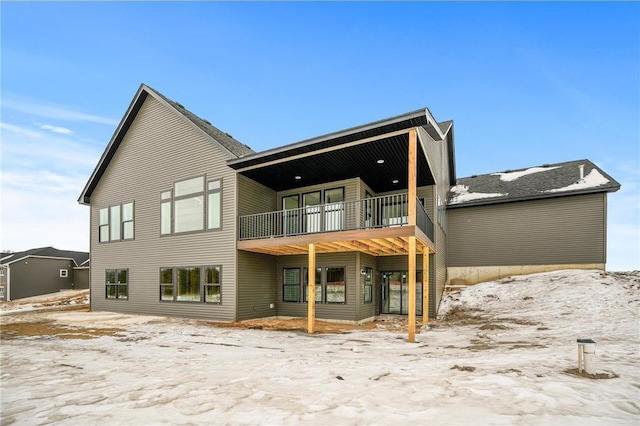 snow covered property featuring a balcony