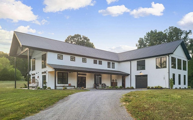 modern farmhouse with a front yard, a porch, and a garage