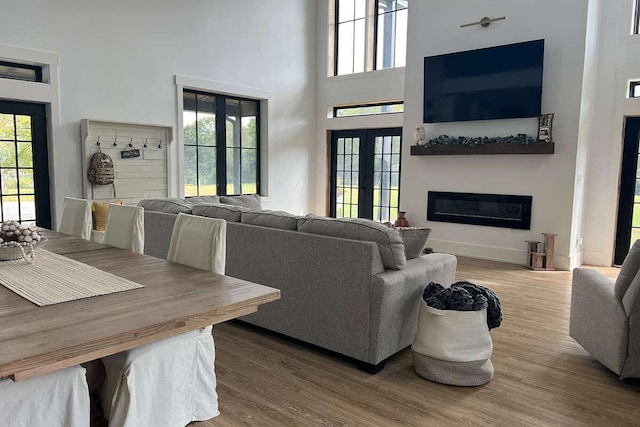 living room with french doors, hardwood / wood-style flooring, and a high ceiling