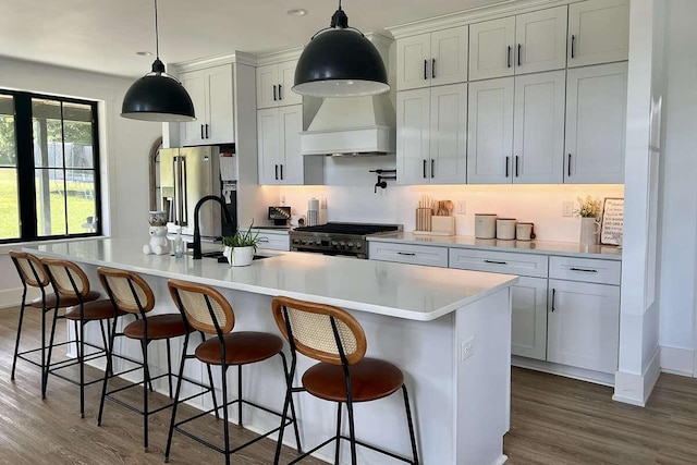 kitchen with a kitchen bar, premium appliances, and a kitchen island with sink