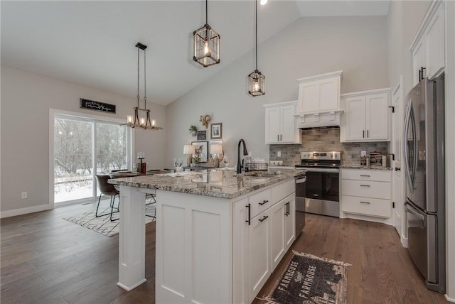 kitchen featuring decorative light fixtures, white cabinetry, stainless steel appliances, and an island with sink