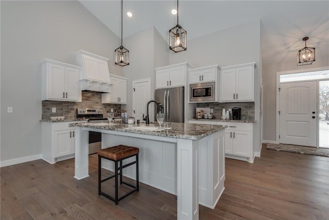 kitchen with white cabinets, premium range hood, and appliances with stainless steel finishes