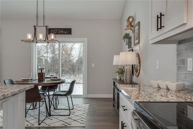 dining space featuring dark hardwood / wood-style floors and an inviting chandelier