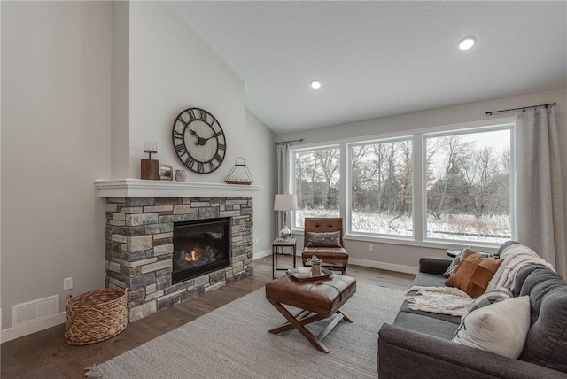 living room with wood-type flooring, a fireplace, and high vaulted ceiling