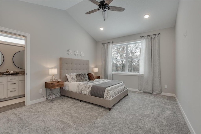 carpeted bedroom featuring ceiling fan, ensuite bathroom, and vaulted ceiling