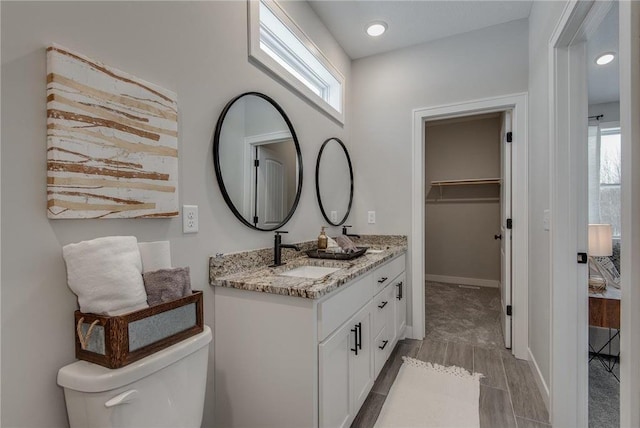 bathroom with a wealth of natural light, vanity, and toilet