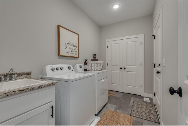 laundry area with washer and clothes dryer, cabinets, and sink