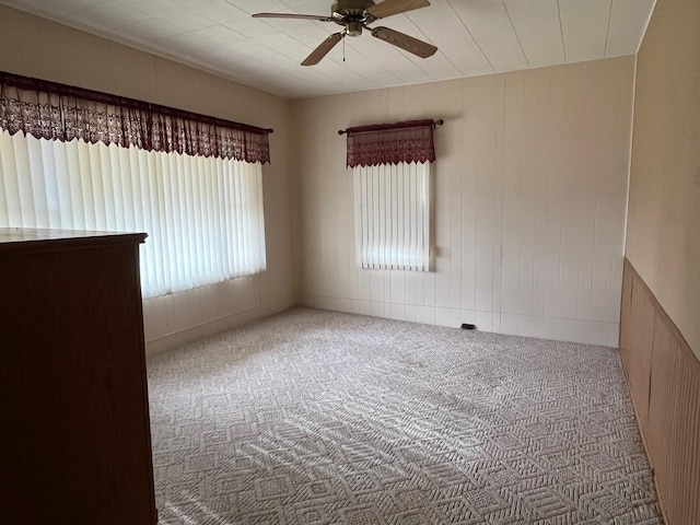 unfurnished room featuring carpet floors, ceiling fan, and a healthy amount of sunlight