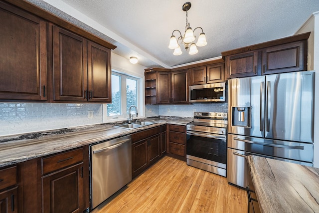 kitchen featuring light hardwood / wood-style floors, stainless steel appliances, dark brown cabinets, pendant lighting, and sink