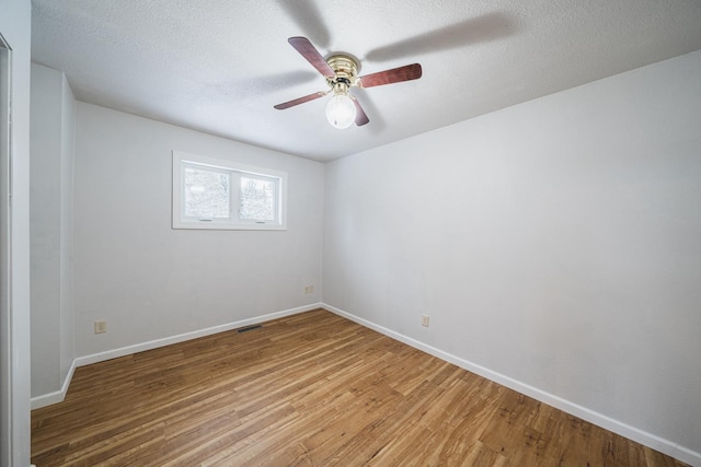 empty room featuring ceiling fan, wood-type flooring, and a textured ceiling