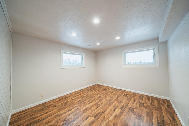 spare room featuring a textured ceiling and dark hardwood / wood-style floors