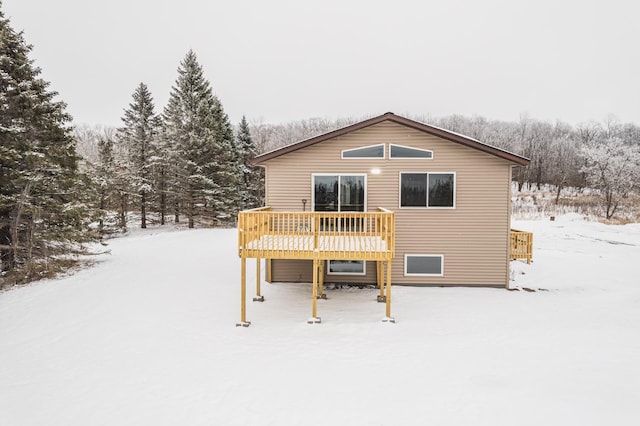 snow covered rear of property featuring a wooden deck