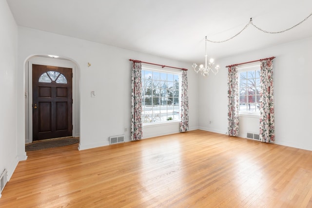 foyer featuring a chandelier, wood-type flooring, and plenty of natural light